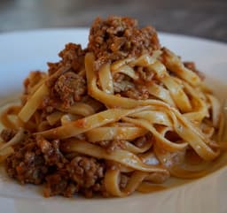 Tagliatelle all'uovo con ragù di prosciutto e funghi
